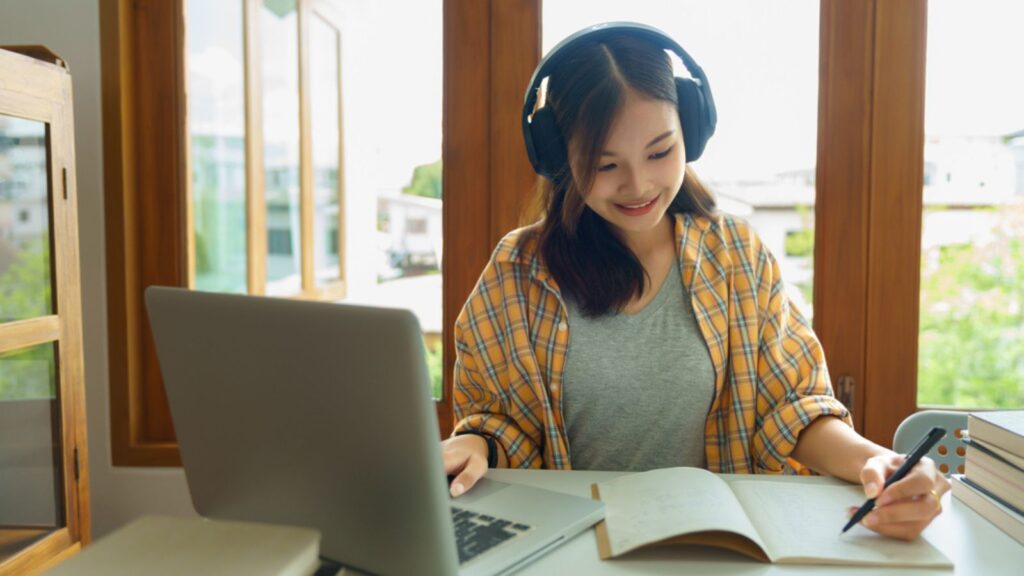 Education and literacy concept, College student girl is listening lecture online and taking notes