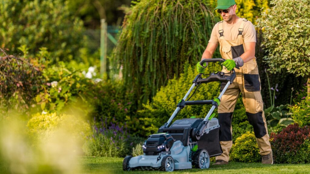 Garden Maintenance Professional Services. Caucasian Gardener Taking Care of the Grass Using Riding Lawn Mower During Summer Season