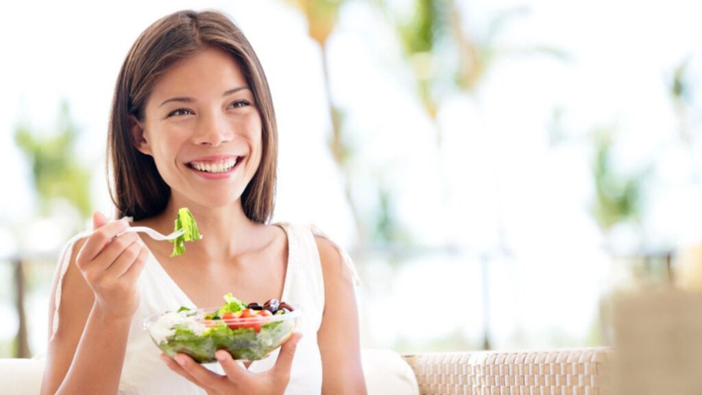 Healthy lifestyle woman eating salad smiling happy