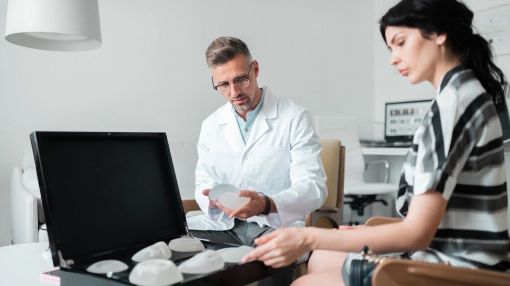 Plastic surgeon and businesswoman choosing suitable breast implants