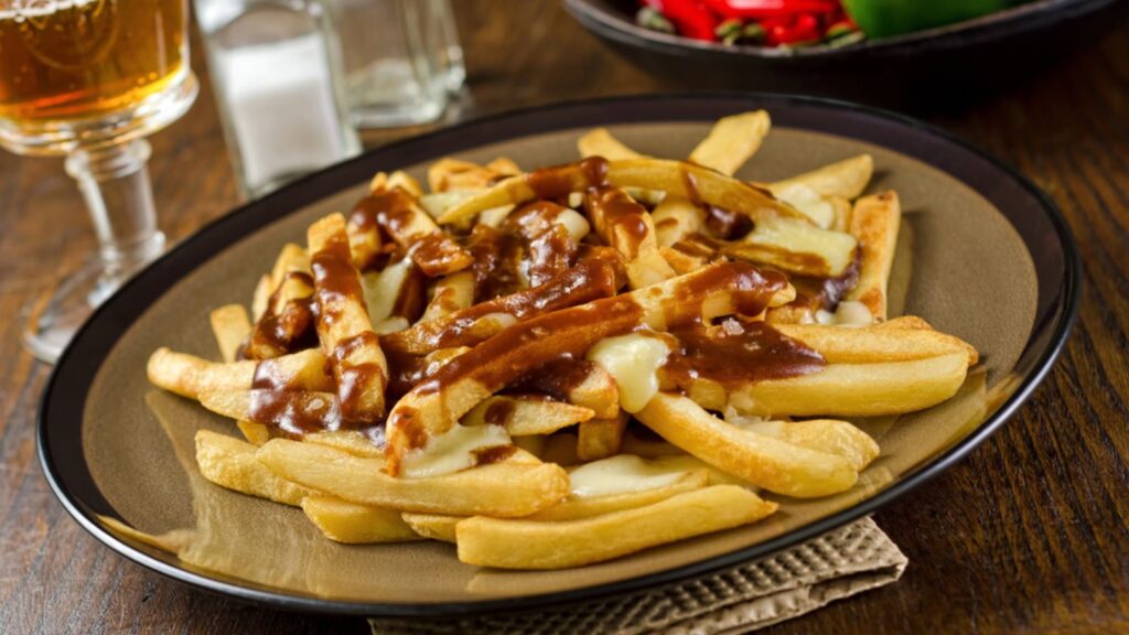 Poutine, a Plate of delicious poutine with french fries with gravy and cheese curds