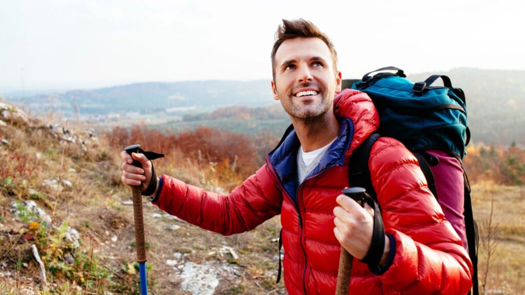 Smiling hiker holding poles