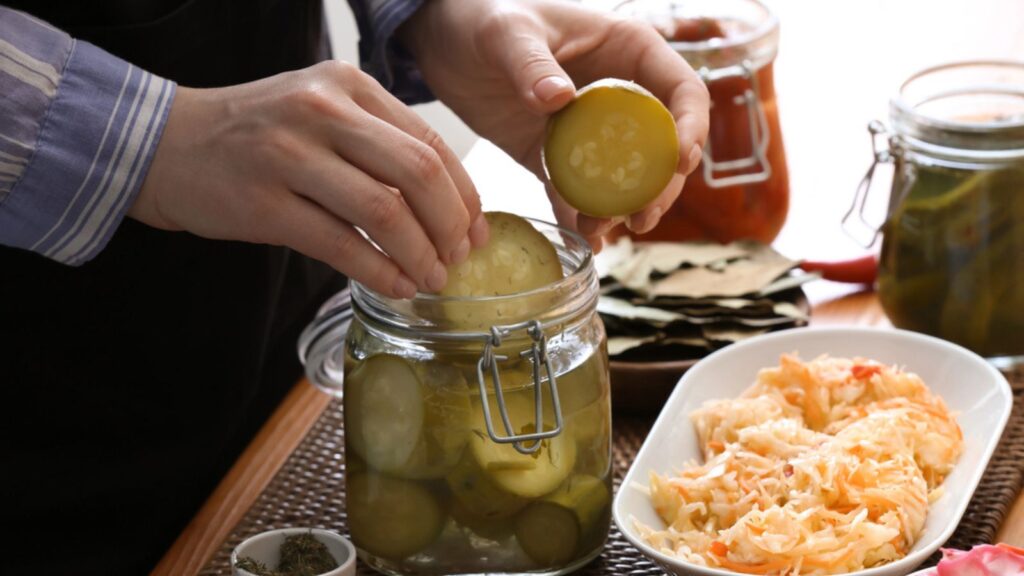 Woman with tasty fermented vegetables in kitchen