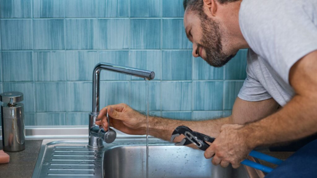 Người kiểm tra vòi nước tại bồn rửa