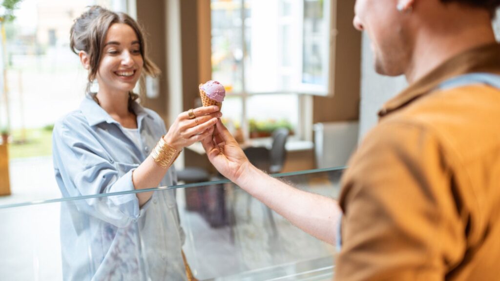 man selling ice cream to woman shop dessert