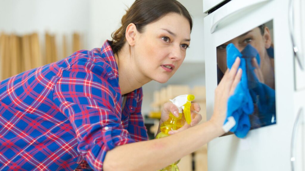 woman cleaning over kitchen spray wipe