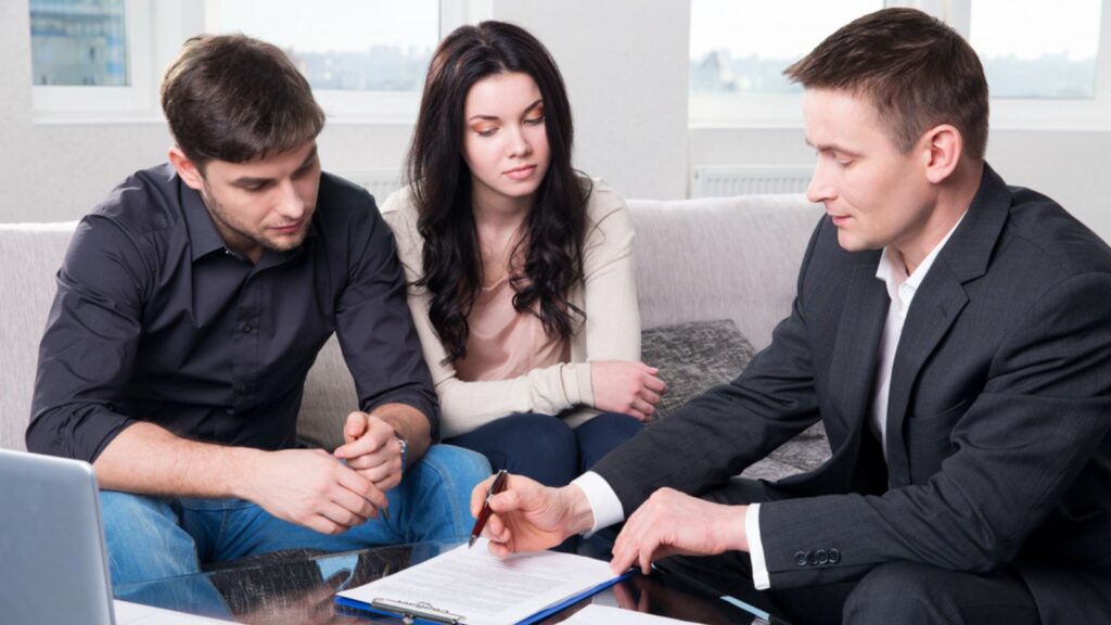 Agent advises the couple, signing documents