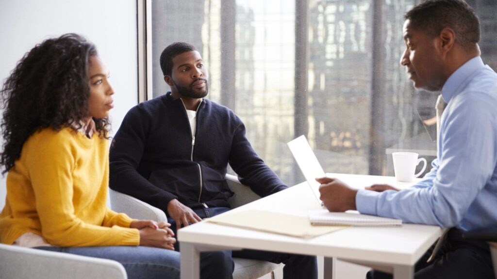 Couple Meeting With Male Financial Advisor Relationship Counsellor In Office