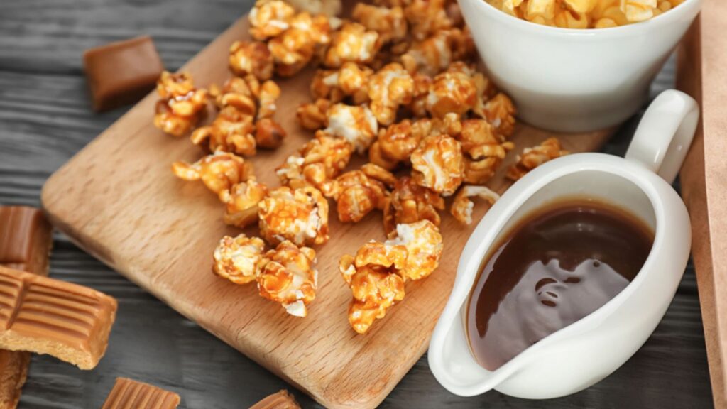 Delicious caramel popcorn on wooden background