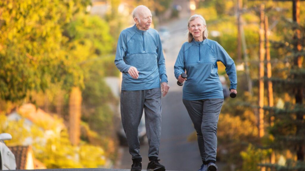 Happy couple walking on street with weights