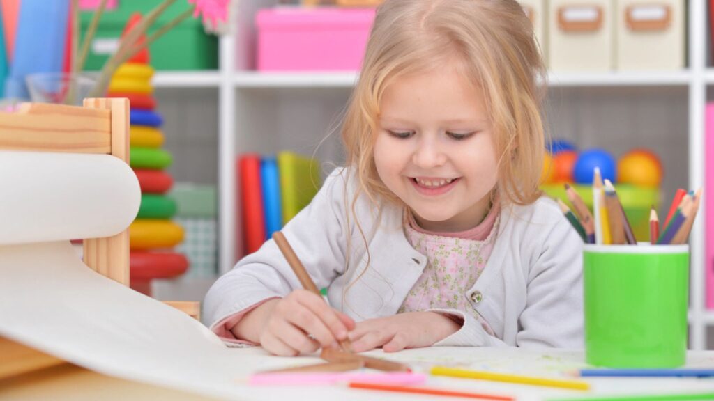 Little girl drawing at her room