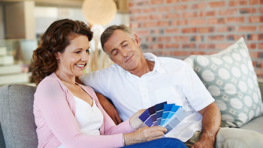 Senior Couple, living room and planning for interior design for paint, new house and renovation discussion. Mature people and property with colour swatch on sofa.