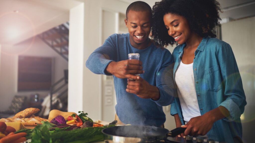 Some pepper goes a long way. Shot of a cheerful young couple taking a photo of the ingredients of the meal they are about to prepare together at home