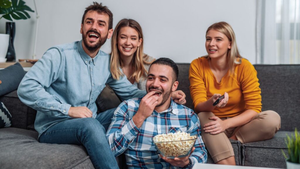 group of friends watching sports game movie popcorn