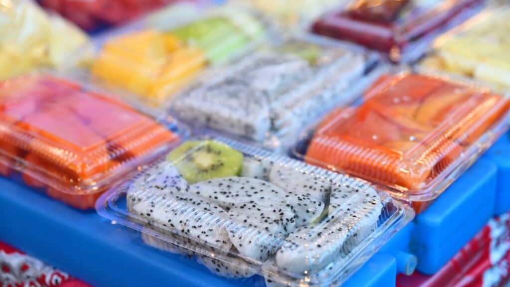 pre-cut fruits neatly arranged in transparent boxes at a market or supermarket stall, enhancing convenience for shoppers