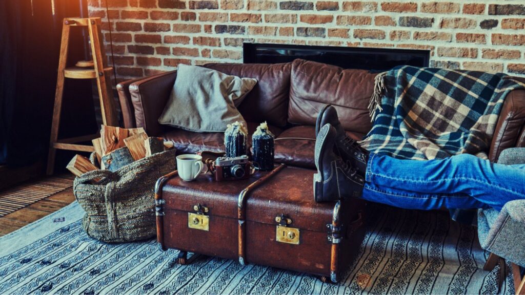 Enjoying little break. Man resting with feet on table while sitting in armchair in cozy living room.
