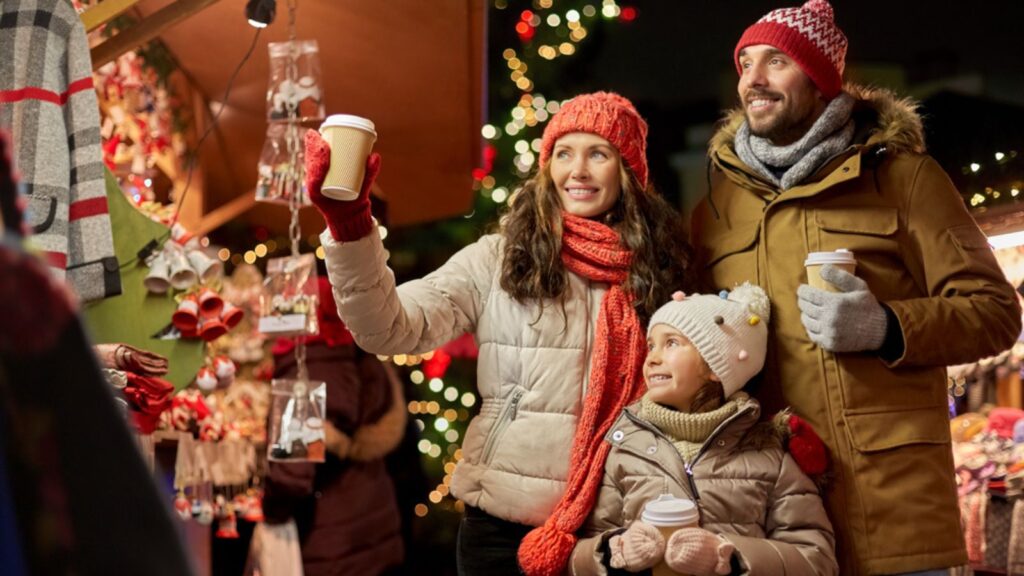Family with takeaway drinks at christmas market