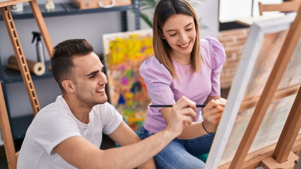 Man and woman artists couple smiling confident drawing at art studio