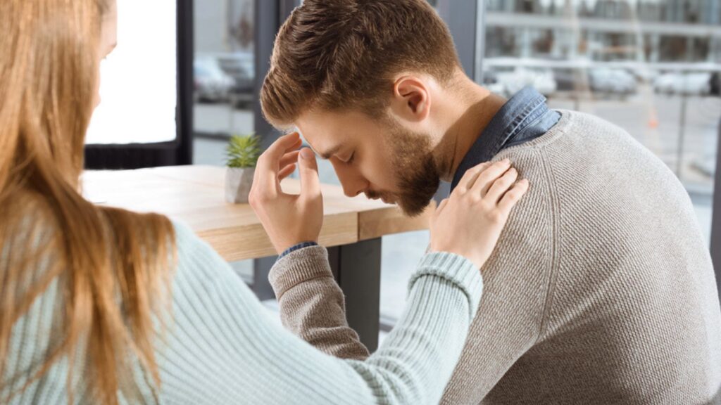Sad man with a woman comforting him