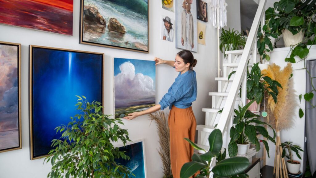 Người phụ nữ treo ảnh trên tường