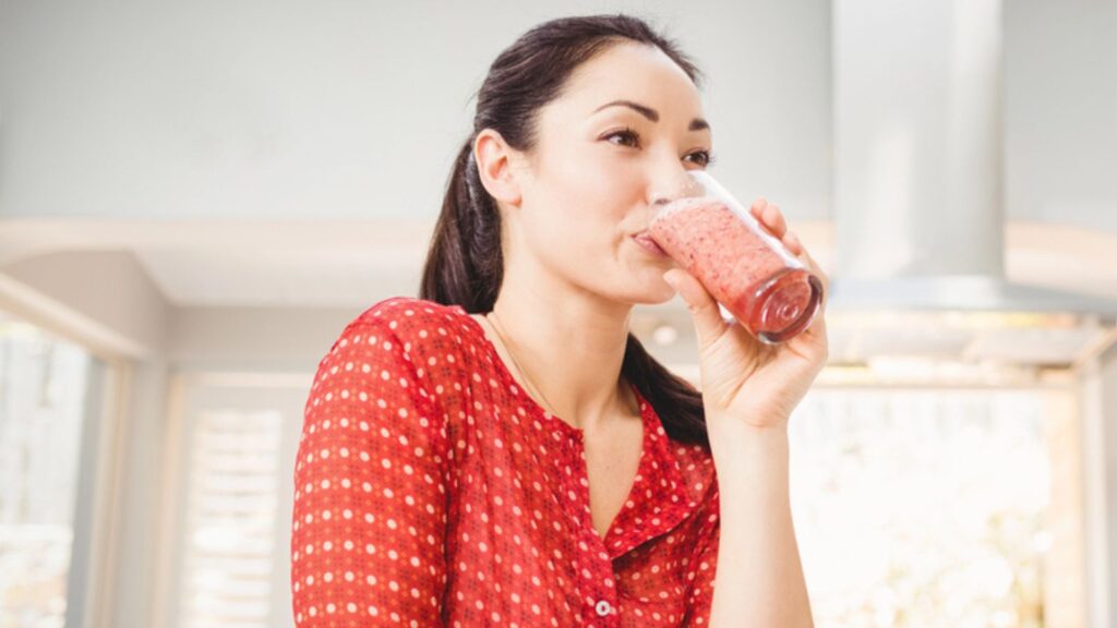 Smiling woman drinking fruit juice