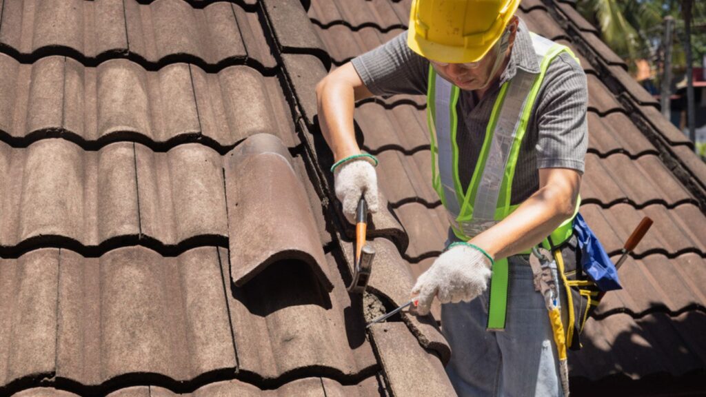 Worker man replace tile of the old roof. Repair roof