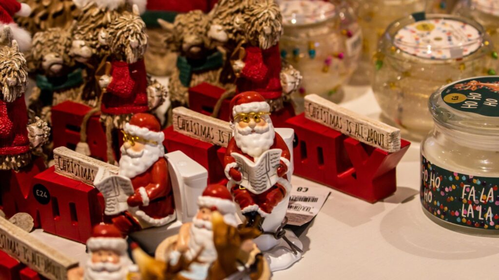 A festive display of Christmas decorations featuring Santa figurines, red train ornaments, and decorative jars. various Santa figures