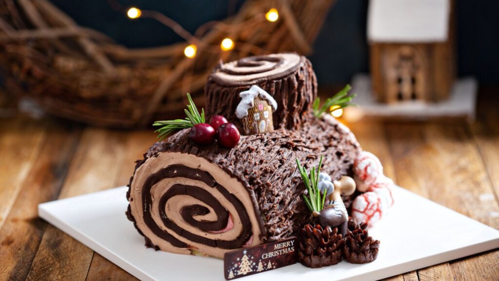 Christmas Yule log roll cake with edible sweet mushrooms and pine cones