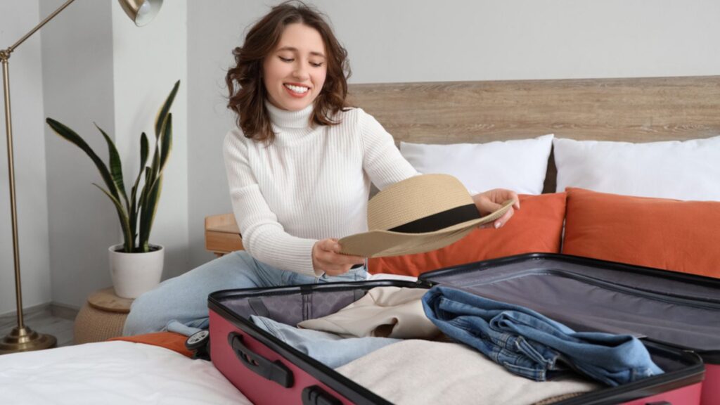 Female tourist unpacking suitcase in room