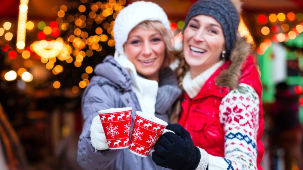Friends drinking spiced wine on Christmas market. Glogg