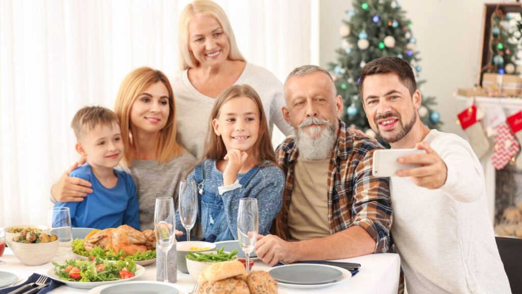 Happy family taking selfie during Christmas dinner at home