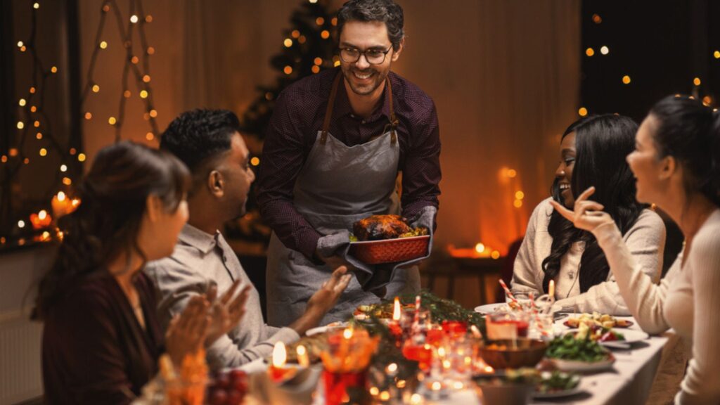 Holidays and celebration concept- multiethnic group of happy friends having christmas dinner at home (1)