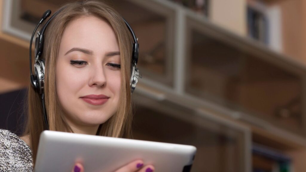 Lady busy with electronic devise. Portrait of beautiful young woman holding tablet PC.