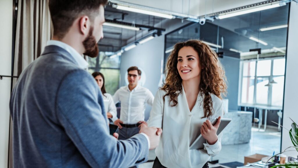 Man and woman are shaking hands in office. Collaborative teamwork. Business professionals