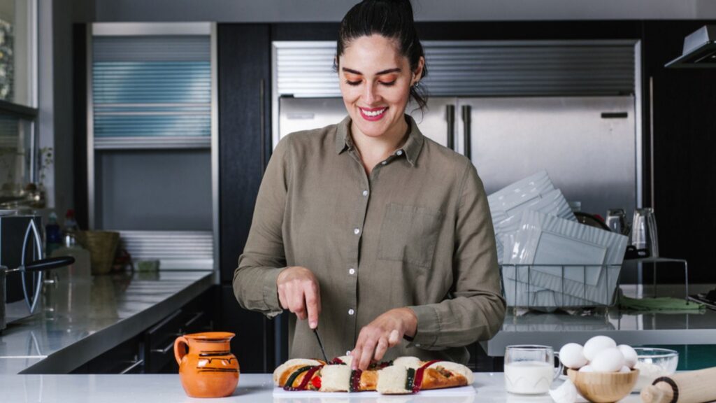 Mexican woman eating rosca de reyes or Epiphany cake, Roscon de reyes with traditional mexican chocolate cup in Latin America
