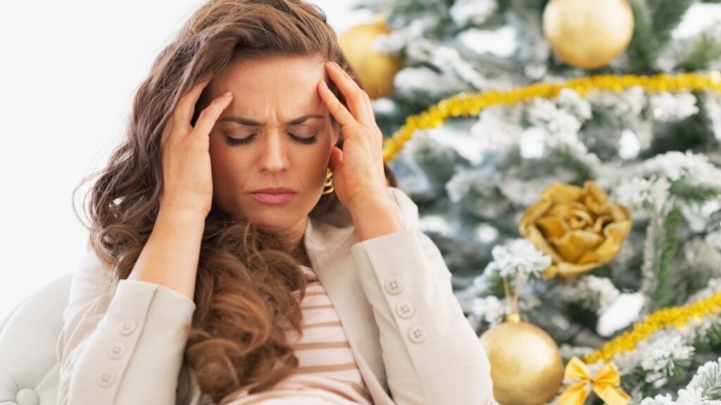Portrait of frustrated young woman near christmas tree