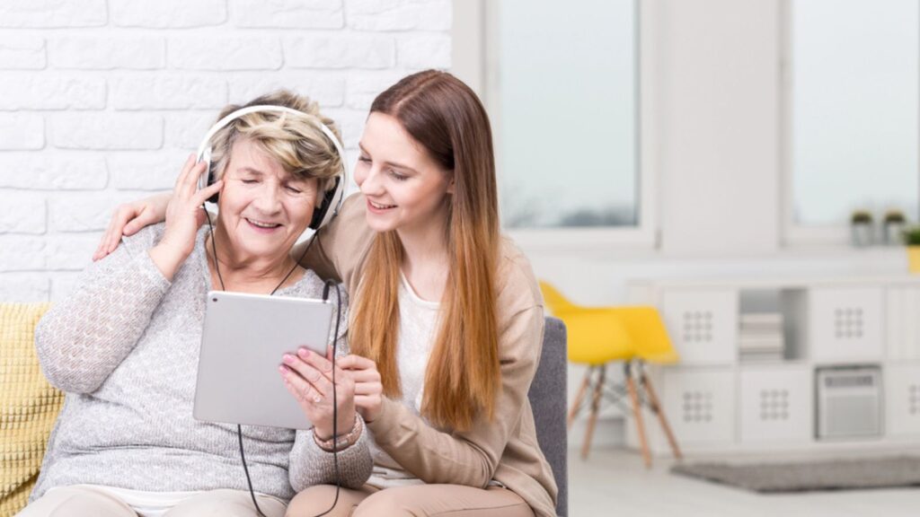 Shot of a senior woman listening to music and her granddaughter sitting next to her