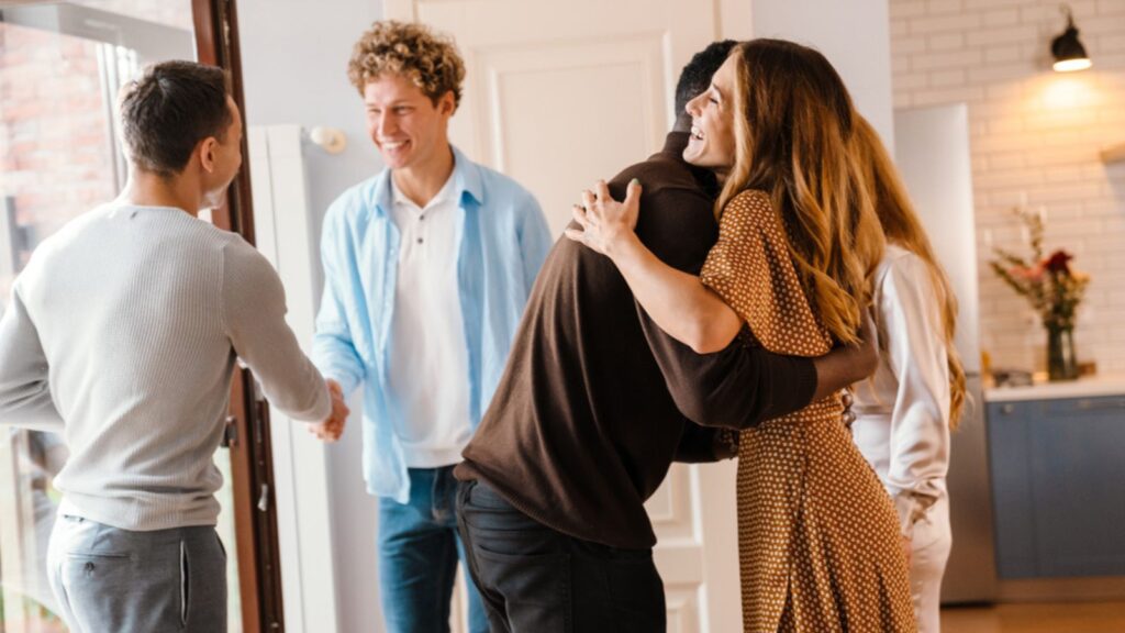 White happy woman greeting her friends during thanksgiving day at home. Leaving guest after party