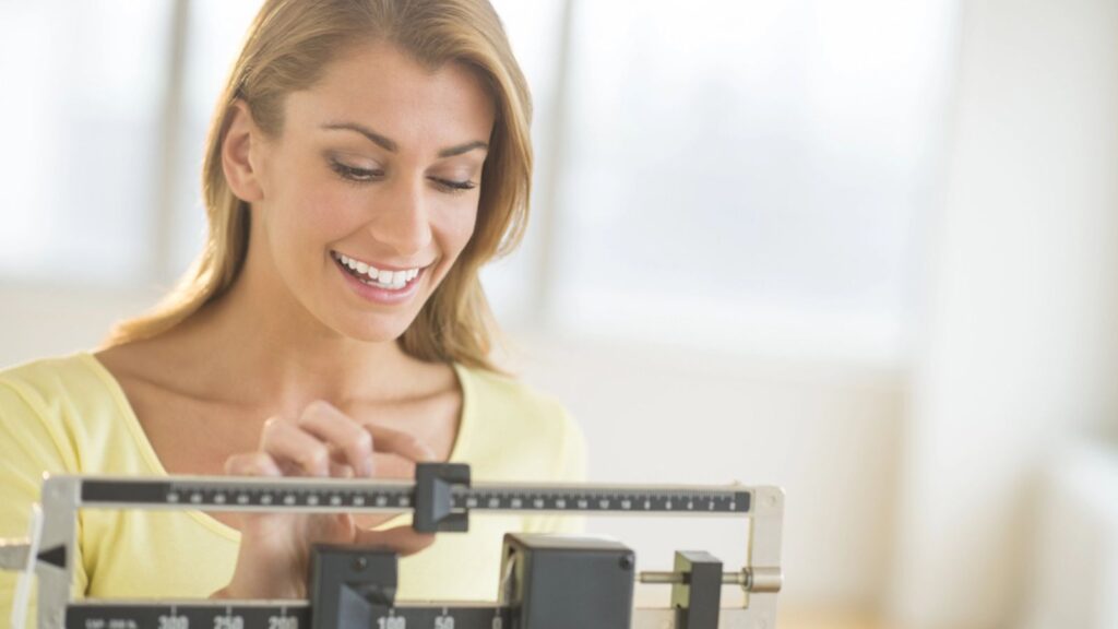 Woman Weighing Herself On Balance Scale