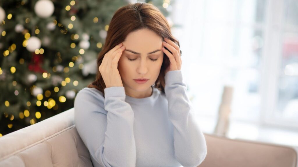 Young woman in grey shirt suffering from headache