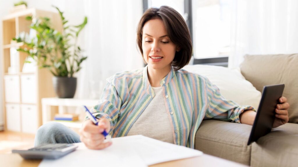 Woman with tablet pc, bills and calculator at home